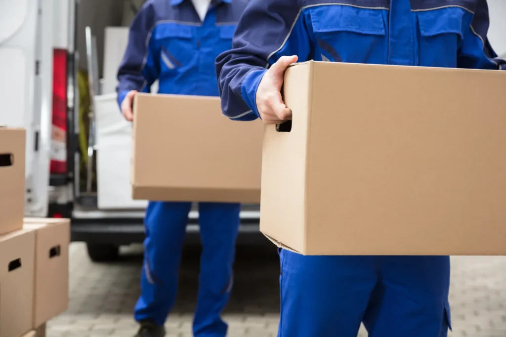 Professional Local Moving Services Team Carrying Cardboard Boxes from Moving Truck